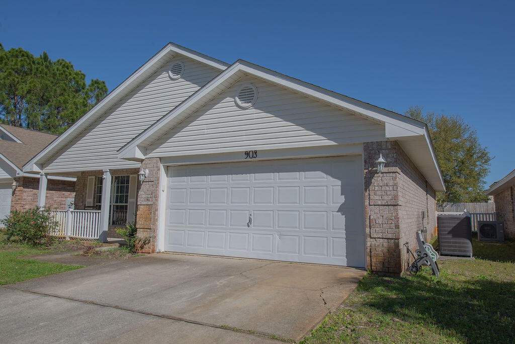 903 Lajolla Lane Mary Esther, FL 32569 - Photo 4 of 47 a front view of a house with a yard and garage