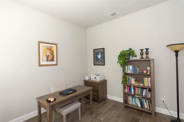 a room with a bookshelf and a wooden floor