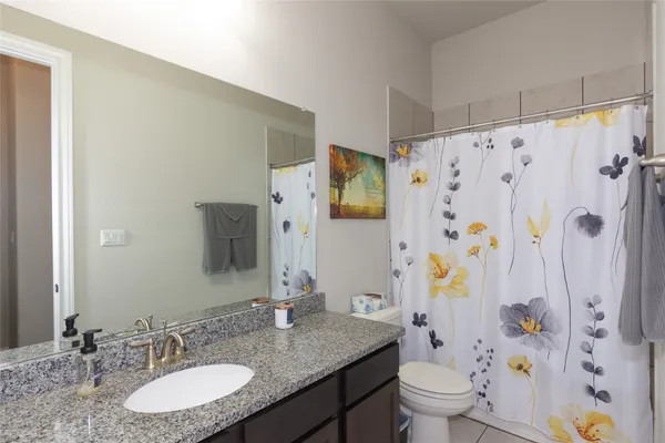a bathroom with a granite countertop sink toilet and shower