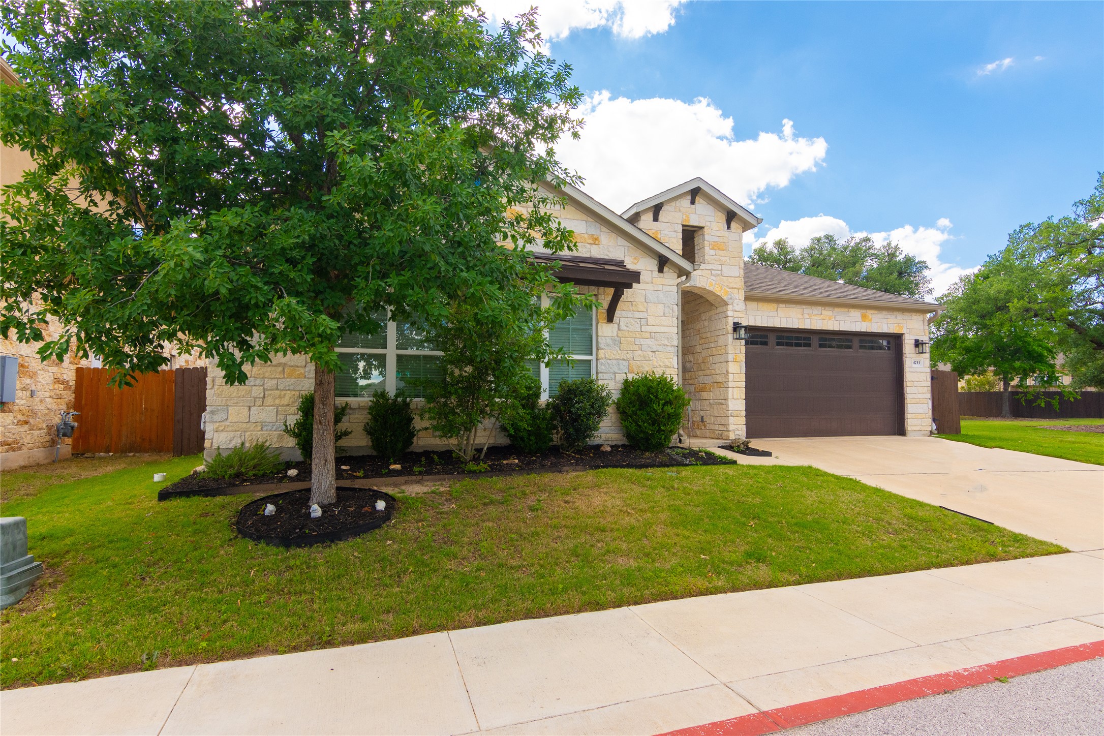4733 Collins Street, Unit 610 Round Rock, TX 78628 - Photo 3 of 36 a view of a white house with a small yard and a large tree