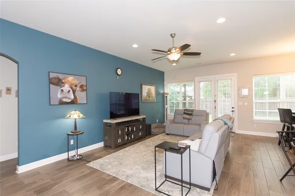 a living room with furniture a flat screen tv and a large window