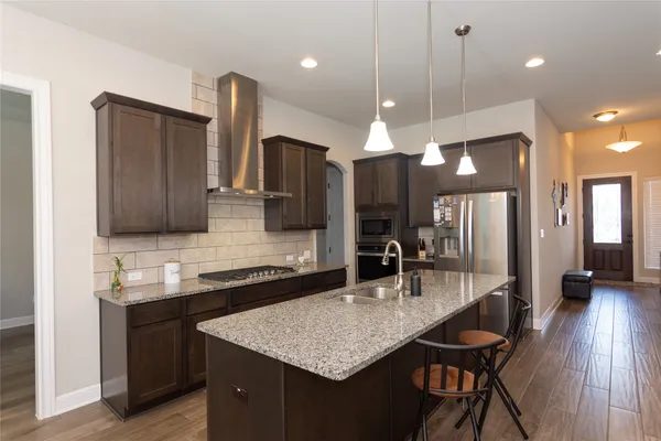 a kitchen with a counter space a sink cabinets and stainless steel appliances