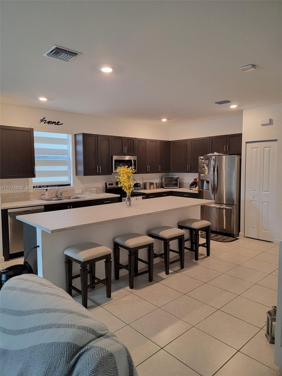 25278 Southwest 108th Avenue, Unit 1 Homestead, FL 33032 - Photo 2 of 10 a living room with stainless steel appliances furniture and a kitchen view