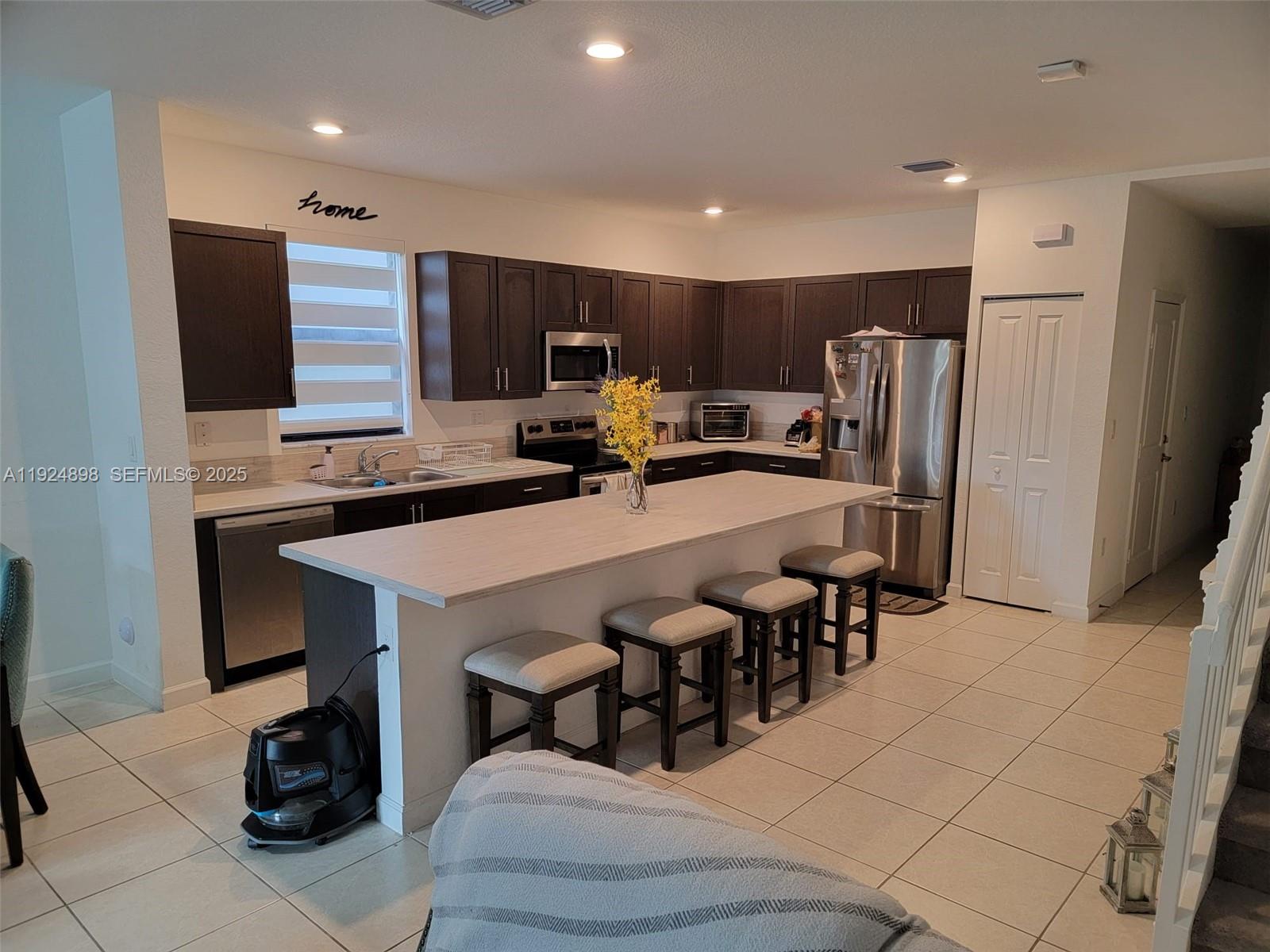 25278 Southwest 108th Avenue, Unit 1 Homestead, FL 33032 - Photo 5 of 10 a kitchen with stainless steel appliances a sink a refrigerator and a refrigerator