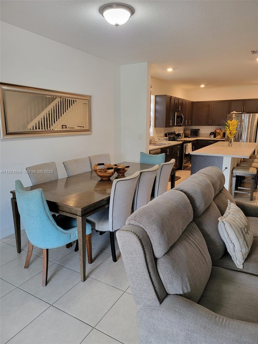 25278 Southwest 108th Avenue, Unit 1 Homestead, FL 33032 - Photo 7 of 10 a living room with furniture a rug and a kitchen view
