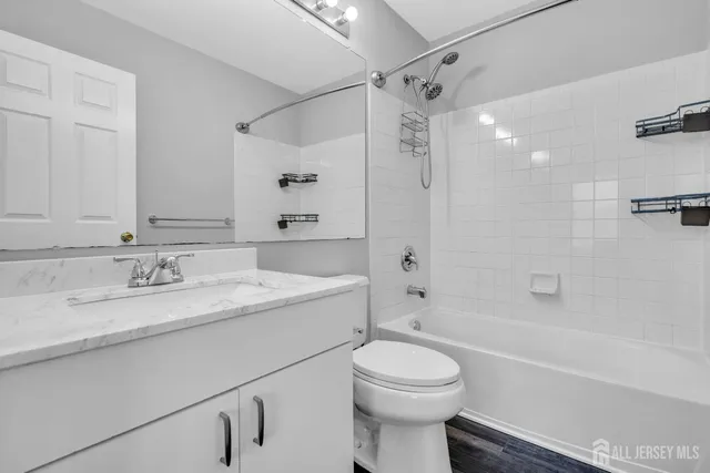 a bathroom with a granite countertop sink a toilet and shower