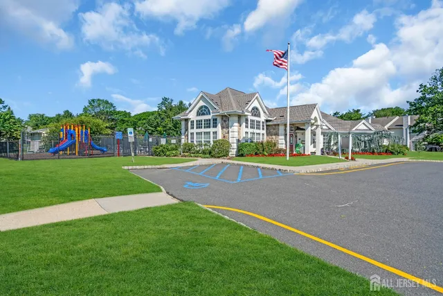 a view of a white house with a big yard and potted plants