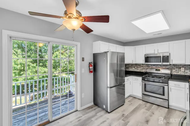 a kitchen with stainless steel appliances granite countertop a refrigerator a stove a sink and dishwasher