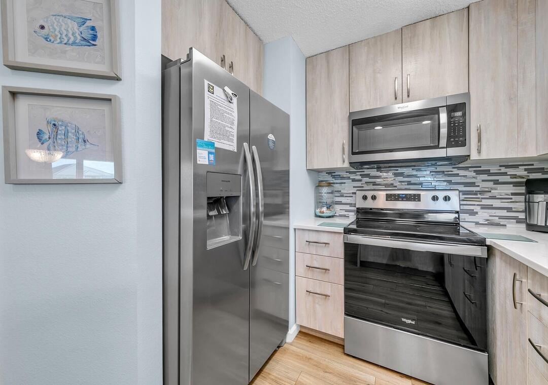 11 Beachside Drive, Unit 832 Santa Rosa Beach, FL 32459 - Photo 10 of 23 a kitchen with stainless steel appliances granite countertop a stove a refrigerator and a microwave