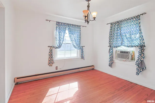 a view of a livingroom with wooden floor and staircase