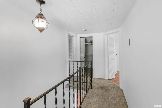a view of a hallway with wooden floor and windows