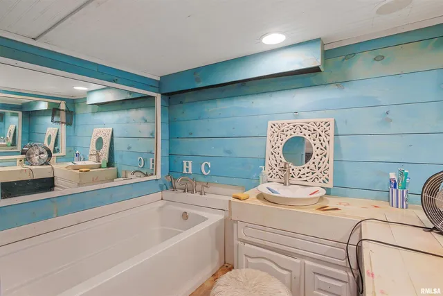 a bathroom with a sink a mirror and a bath tub