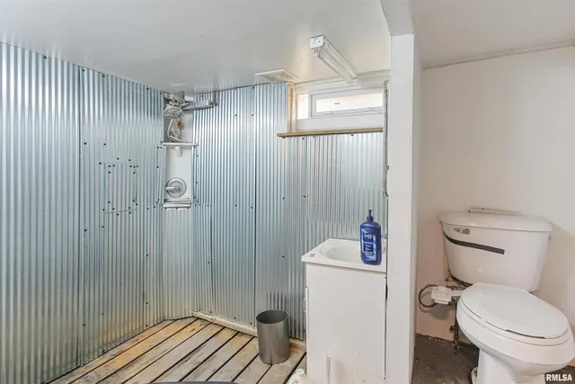a bathroom with a toilet a sink and shower