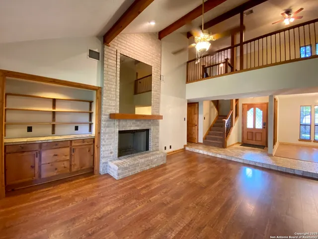 a view of a hallway with wooden floor and a chandelier
