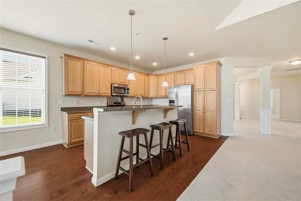 a kitchen with stainless steel appliances granite countertop sink stove and refrigerator