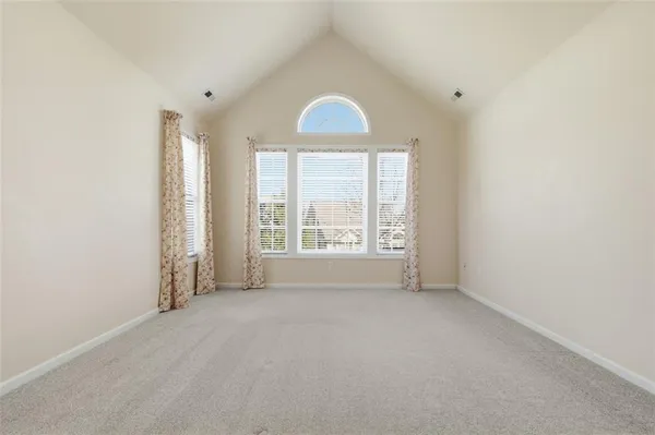 an empty room with windows and bathroom