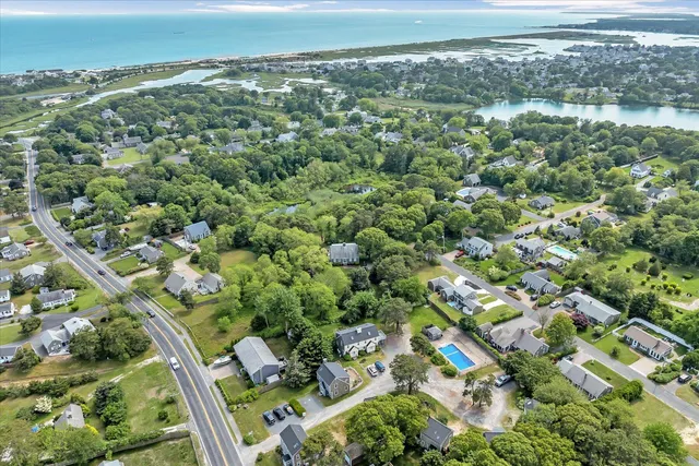 an aerial view of residential houses with outdoor space and trees