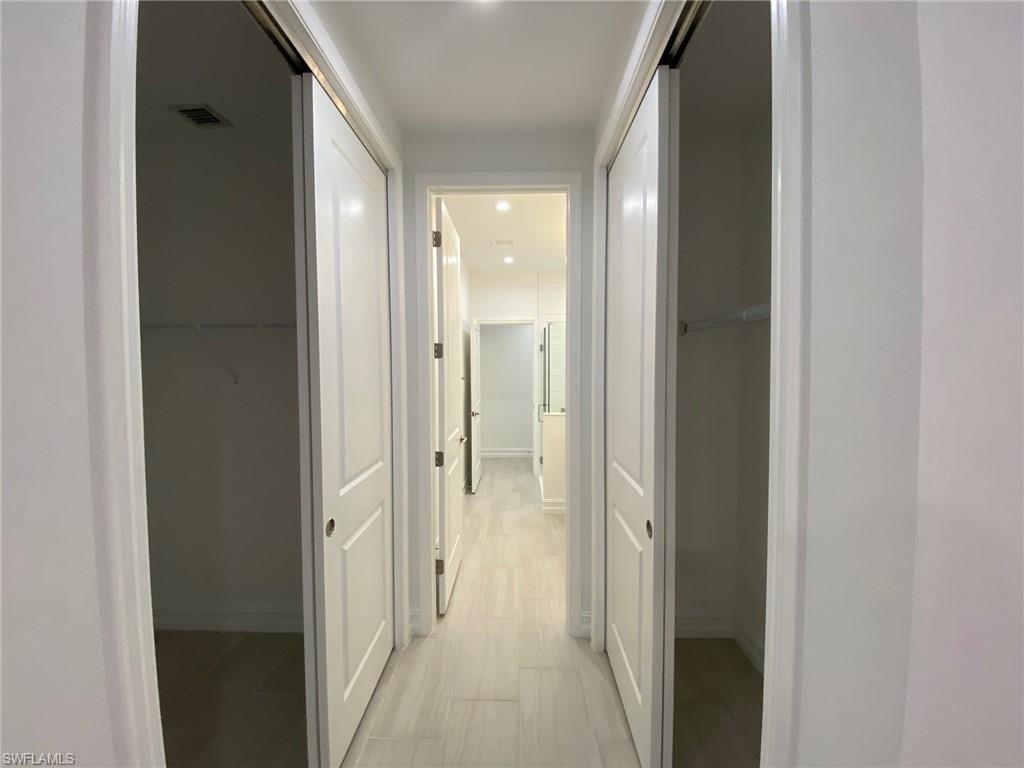 7530 Rockefeller Drive Naples, FL 34119 - Photo 7 of 18 Hallway featuring light wood-finish flooring, recessed lighting, and white panel doors