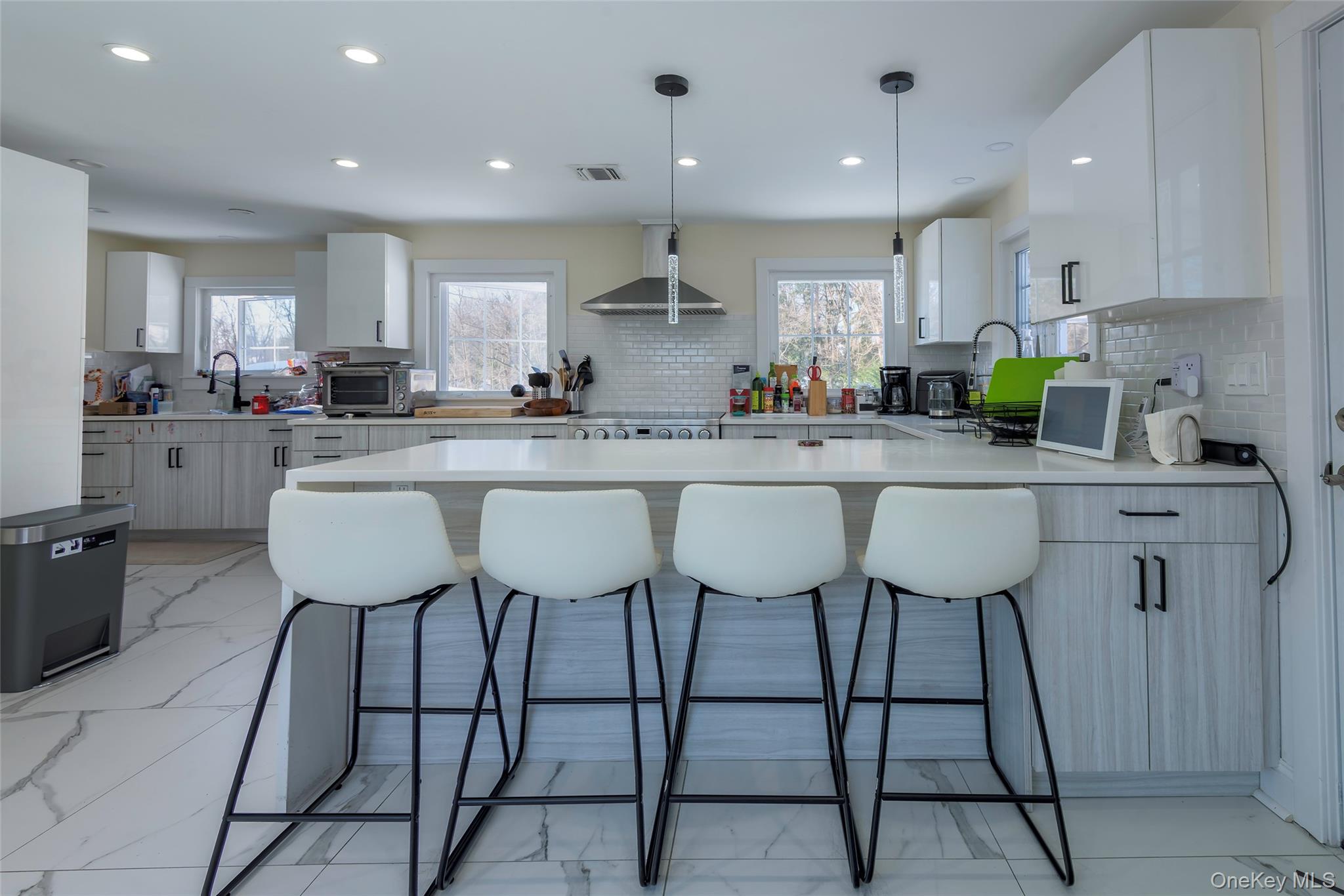20 North Ravine Road Great Neck, NY 11023 - Photo 11 of 27 a kitchen with stainless steel appliances granite countertop a table chairs sink and cabinets