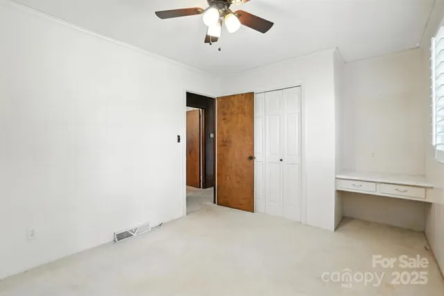 an empty room with chandelier fan