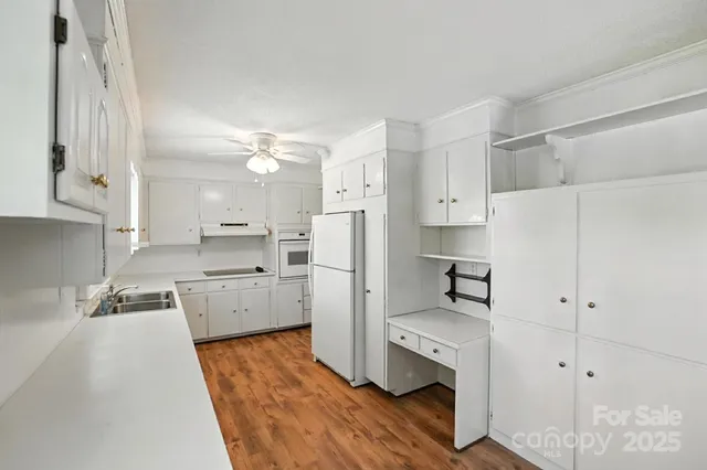 a kitchen with white cabinets and refrigerator