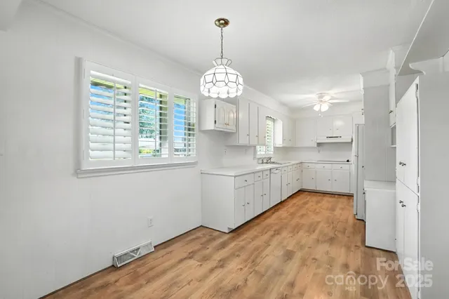 a large white kitchen with a large window