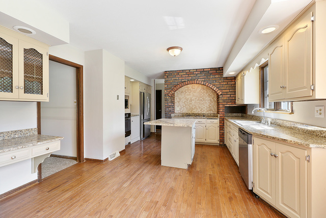 3033 East Hickory Lane Crete, IL 60417 - Photo 7 of 18 a large kitchen with granite countertop a large counter top a sink stainless steel appliances and cabinets