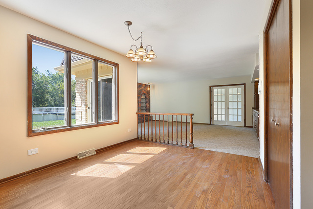 3033 East Hickory Lane Crete, IL 60417 - Photo 8 of 18 a view of an empty room with a window and wooden floor