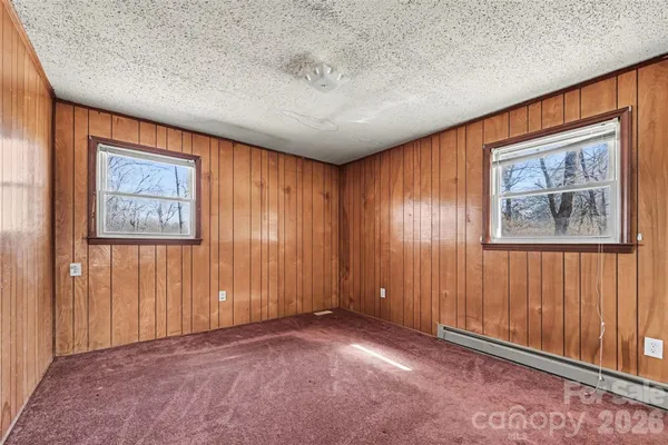 an empty room with windows & cabinet area