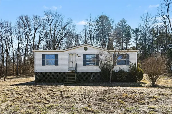 a front view of a house with a yard covered with snow