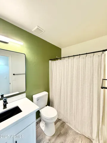 a bathroom with a sink a toilet and a mirror