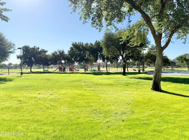 a view of grassy field with benches and trees all around