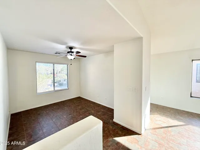 a view of a livingroom with a ceiling fan and window