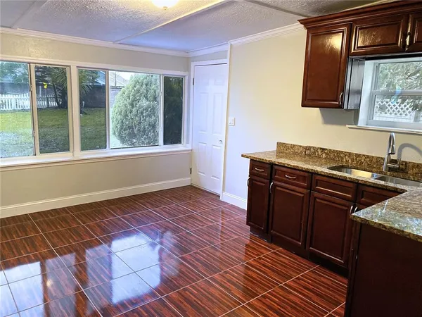 a kitchen with granite countertop a stove and a wooden cabinets