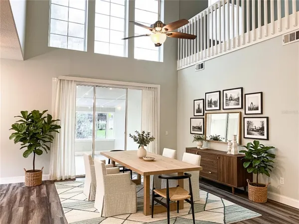 a living room with furniture a potted plant and a large window