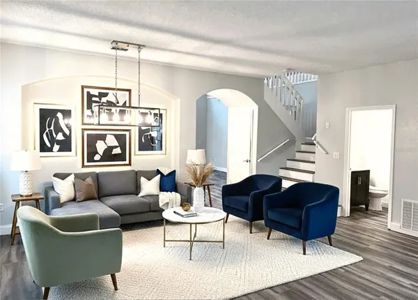 a living room with furniture and a wooden floor