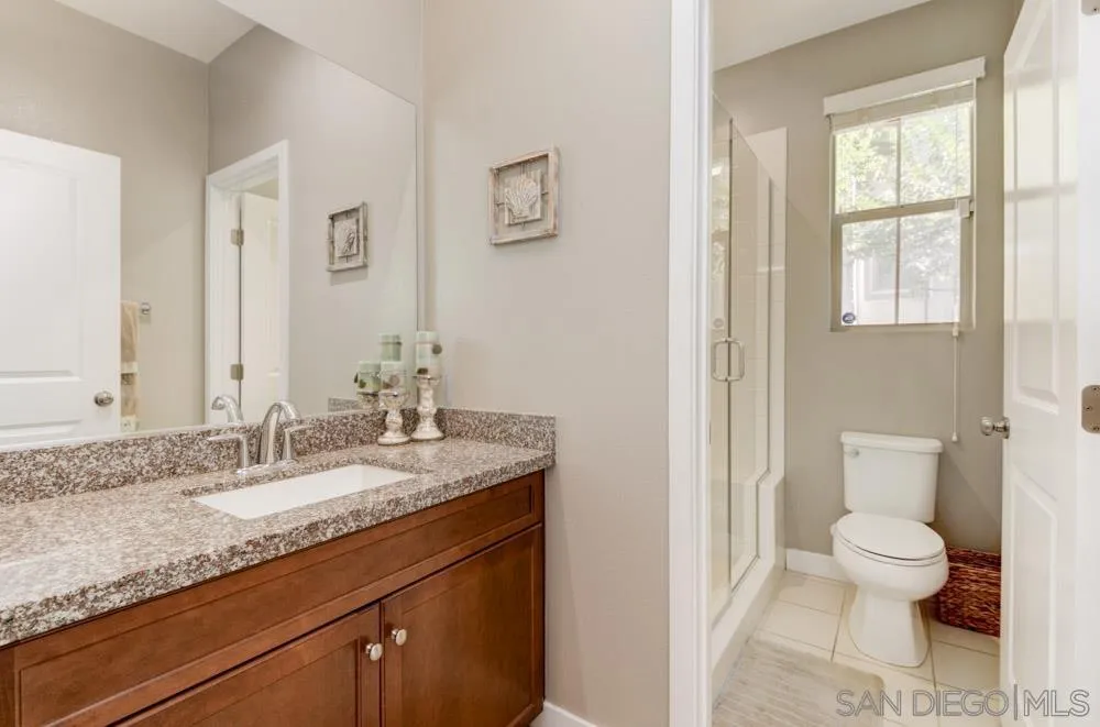 7508 Eagle Drive Santee, CA 92071 - Photo 17 of 25 a bathroom with a granite countertop sink a toilet and a window