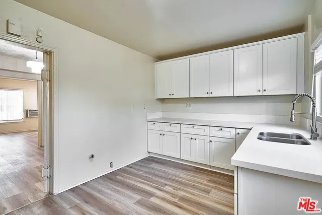 a kitchen with granite countertop white cabinets and white appliances