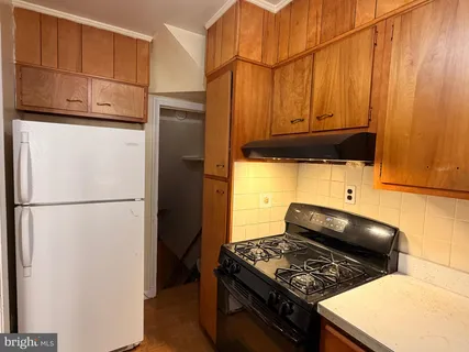 a kitchen with stainless steel appliances granite countertop a refrigerator and a stove