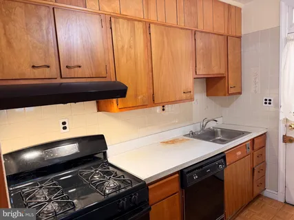 a kitchen with a sink cabinets and a stove top oven