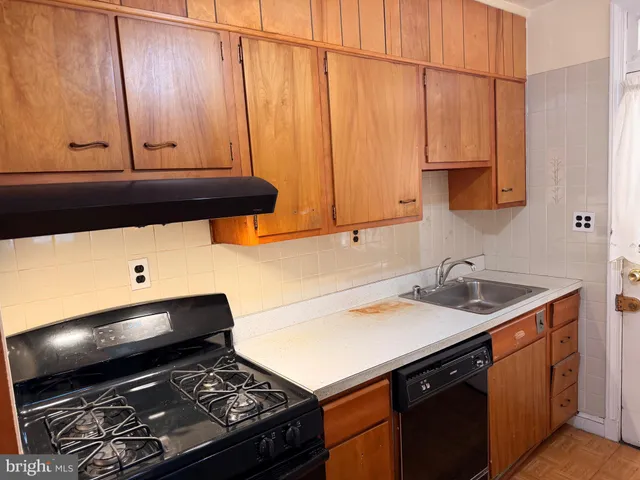 a kitchen with a sink cabinets and a stove top oven