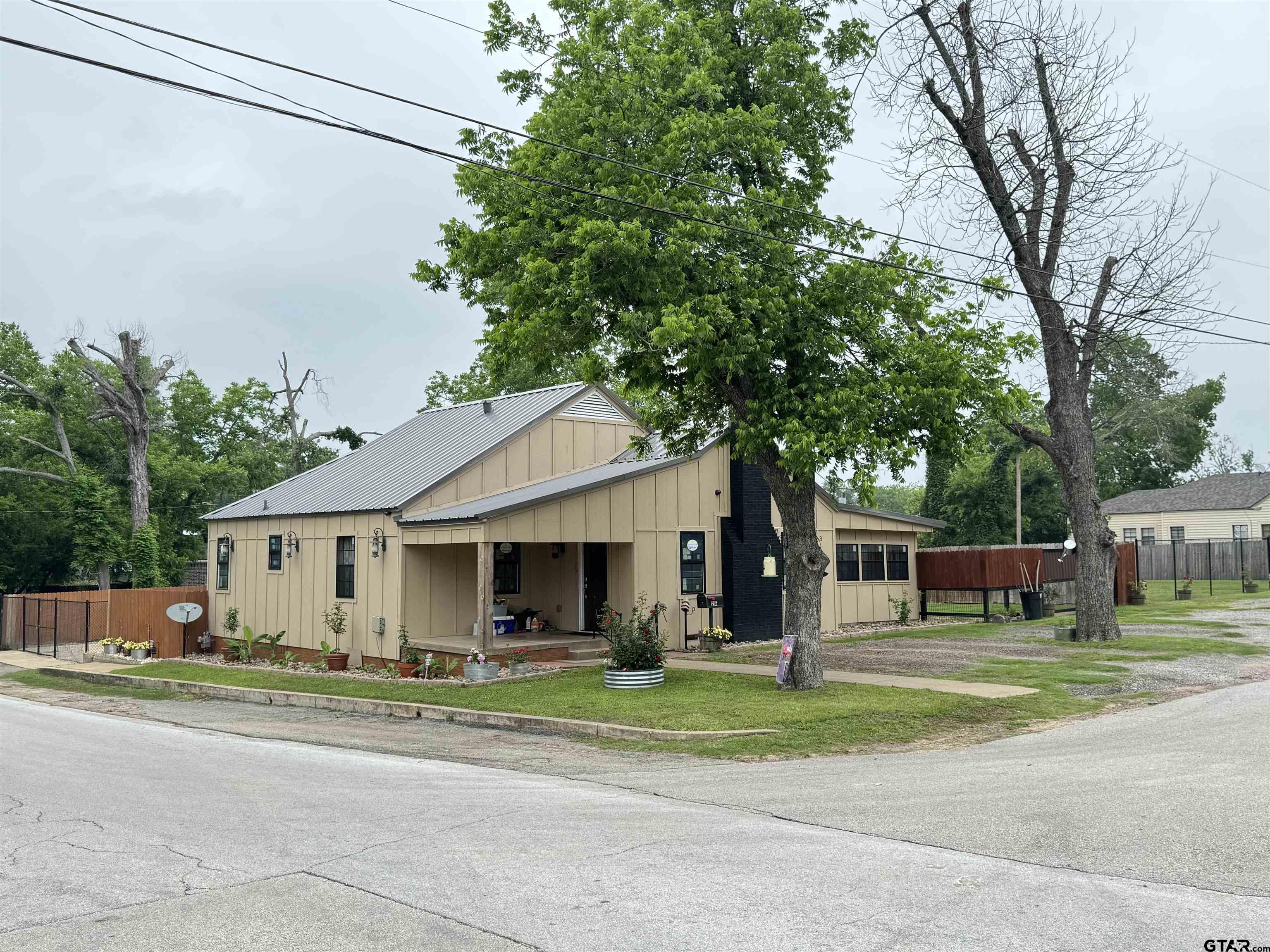 216 Rogers Avenue Henderson, TX 75654 - Photo 2 of 20 a front view of a house with a garden and trees