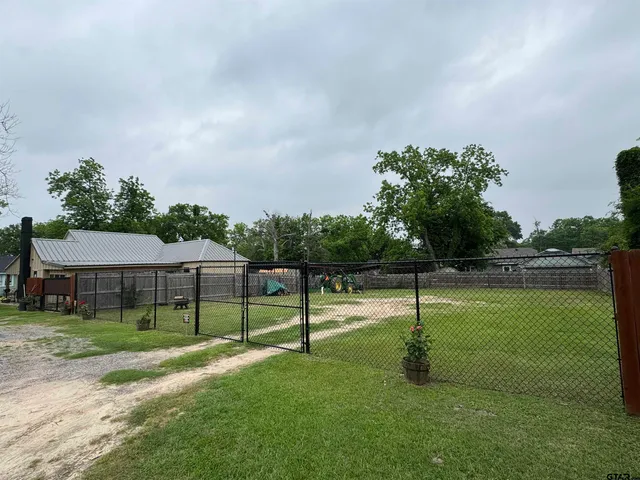 a view of a white house with a yard and sitting area