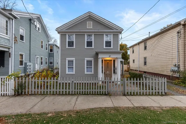 a front view of a house with iron fence
