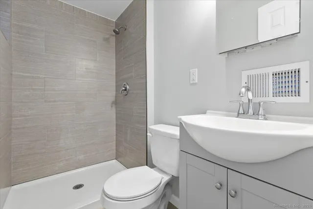 a bathroom with a sink a toilet and shower