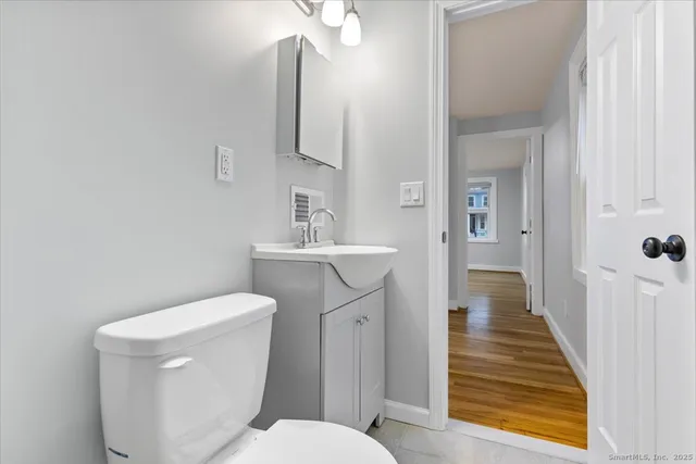 a bathroom with a toilet sink and mirror