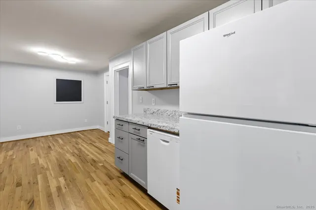 a view of a kitchen with a sink and wooden floor