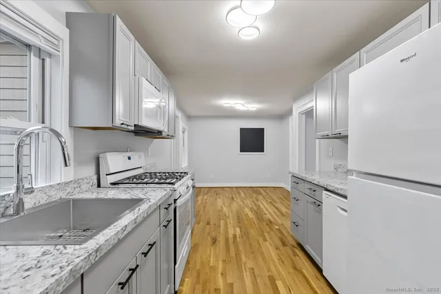 a kitchen with granite countertop a sink stainless steel appliances and cabinets