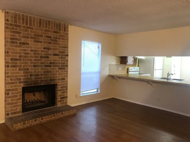 a kitchen with granite countertop wooden floors and a fireplace