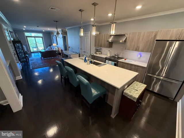 a large kitchen with a table chairs refrigerator and microwave